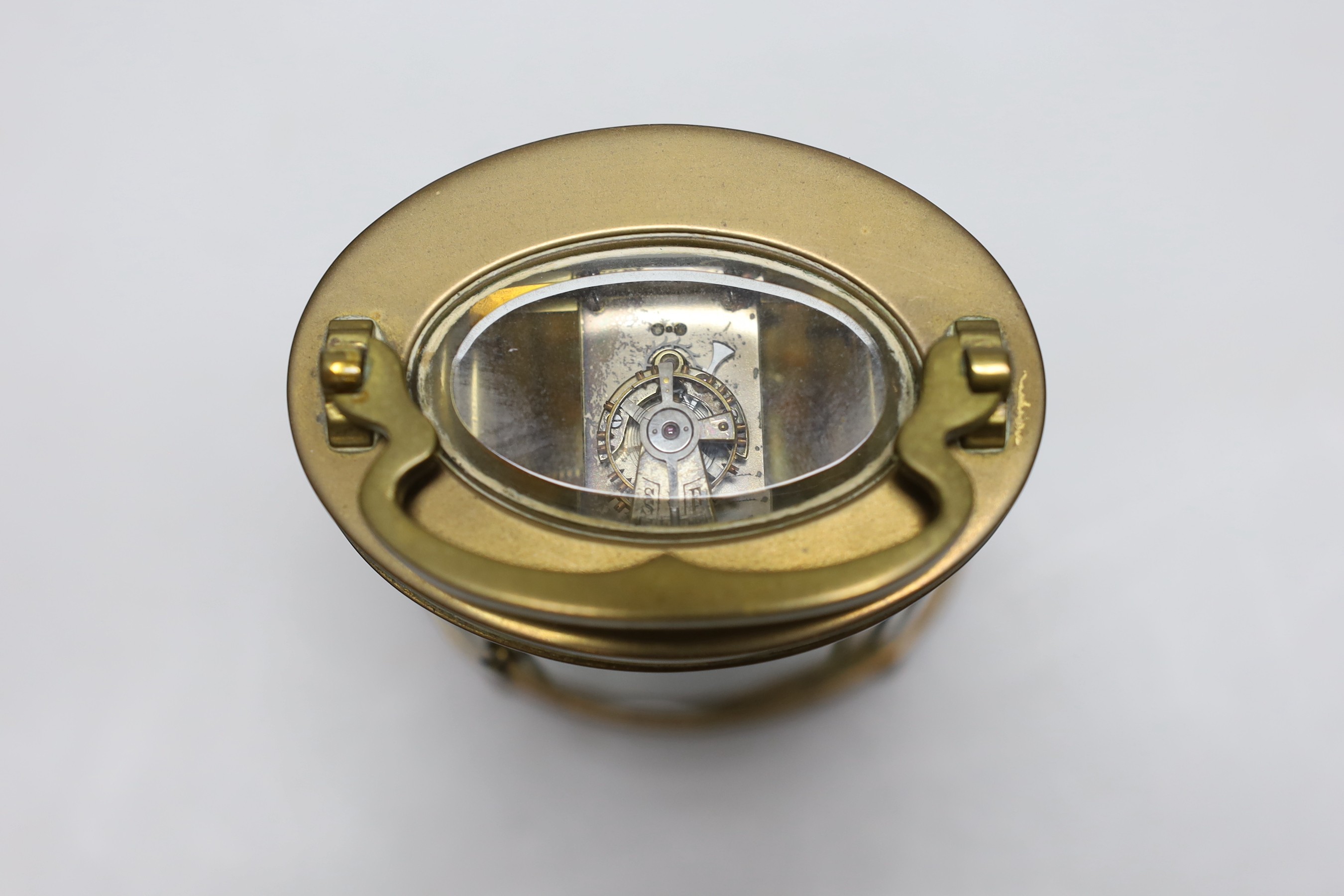 A French oval brass carriage timepiece, 11cms high